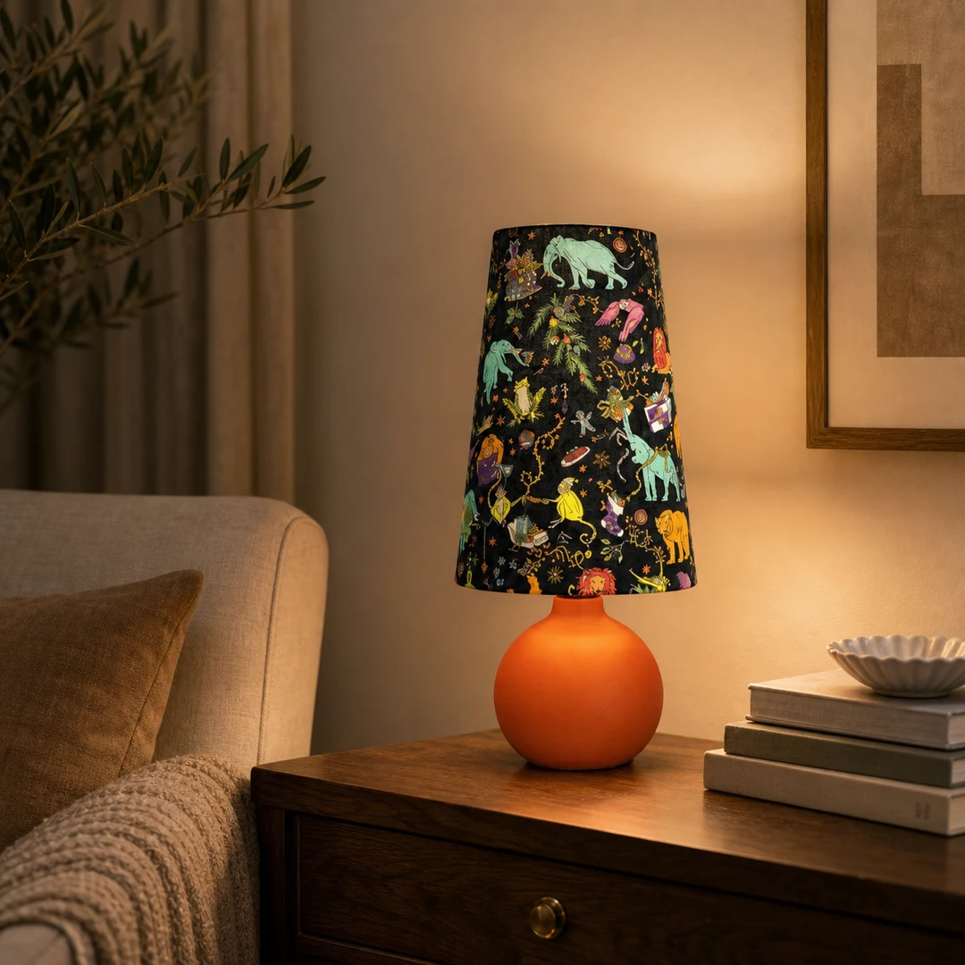 Lampada da tavolo in tessuto colorato, posizionata su un comodino in una calda stanza.