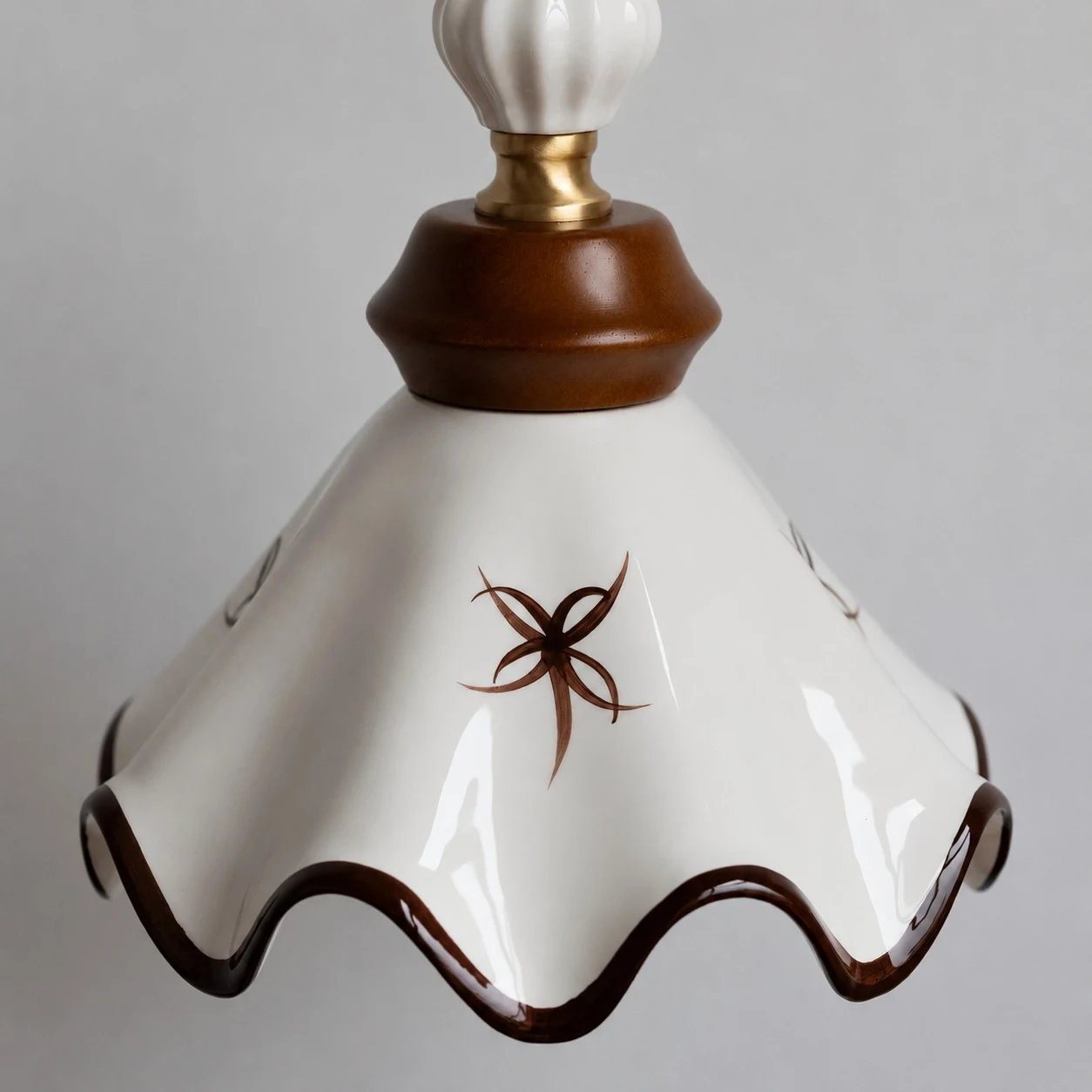 Dettaglio del paralume in ceramica smerlato dipinto a mano.