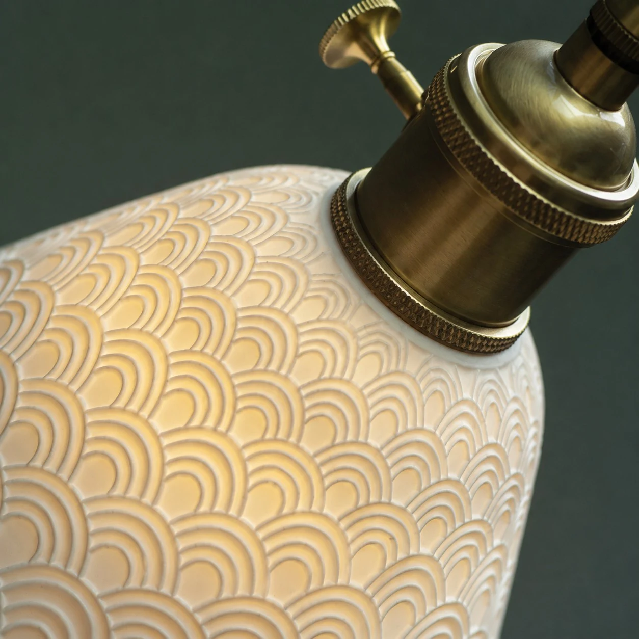 Presa in ottone e dettaglio con texture ceramica in rilievo.